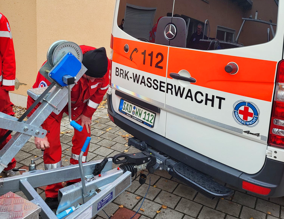 Ein Wasserwachtskamerad beschäftigt sich mit der Funktionsweise der Anhängerkupplung.